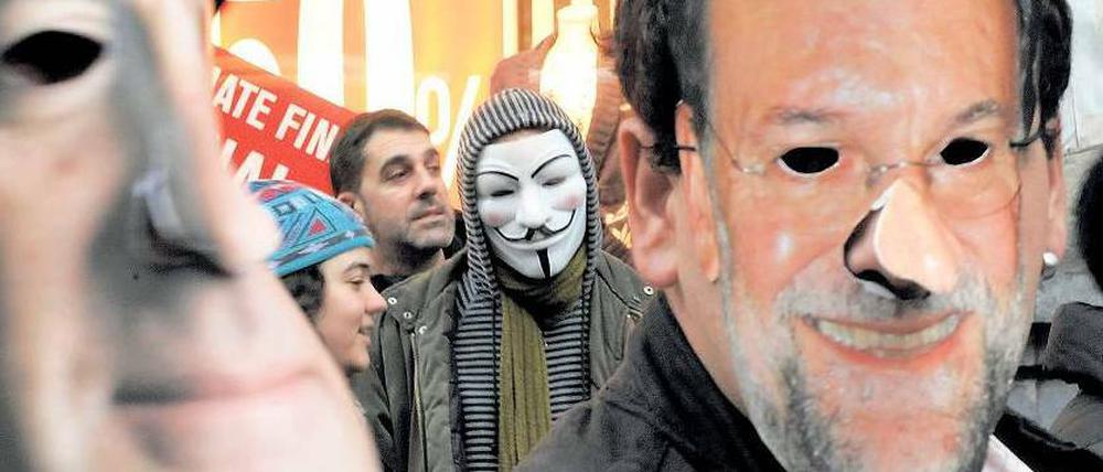 Occupy Madrid. Erster Protest gegen die Reformen von Präsident Mariano Rajoy, dessen Maske rechts zu sehen ist.