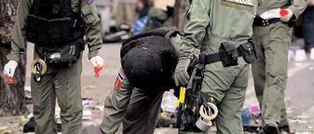 Explosionen. Thailändische Polizisten untersuchen den Tatort in Bangkok. Foto: AFP