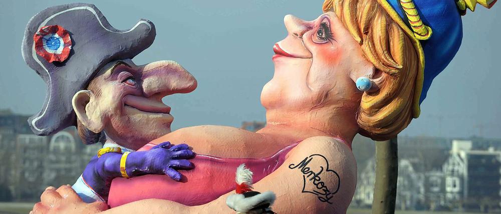 Das gute Verhältnis zwischen dem französischen Staatschef und der Bundeskanzlerin sorgt auch auf dem Rosenmontagsumzügen für Spott.