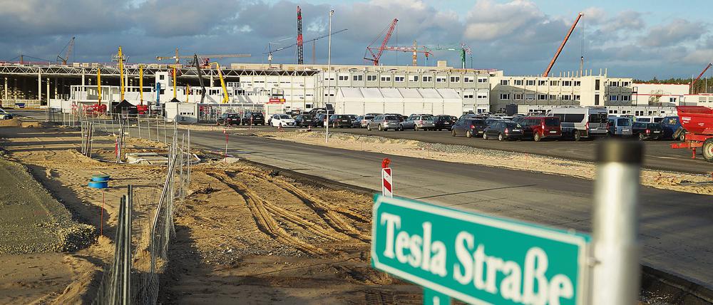 Grünheide: Blick auf das Straßenschild „Tesla Straße 1“ vor der Baustelle der Tesla-Fabrik.