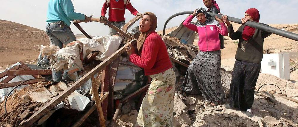Eine Palästinenserfamilie bei Hebron in den besetzten Gebieten mit den Überresten ihrer Unterkunft, nachdem die israelische Armee diese mit Bulldozern hat zerstören lassen.