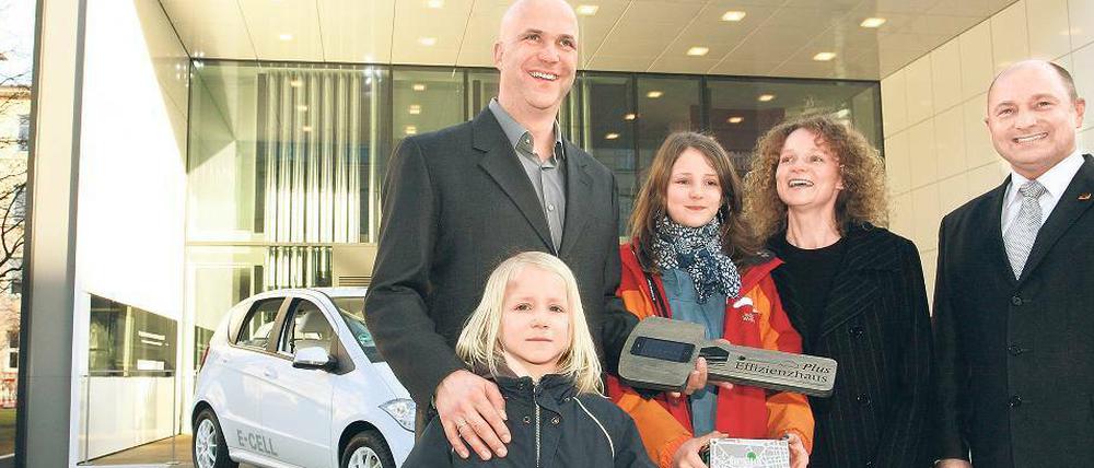 Die Testbewohner: Vater Jörg Welke, die Kinder Lenz (vorne) und Freya sowie Mutter Simone Wiechers bei der symbolischen Schlüsselübergabe durch Baustaatssekretär Rainer Bomba. 