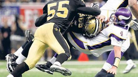 In den Boden gestampft. Die Saints-Profis Scott Fujita und Anthony Hargrove vergreifen sich an Minnesotas Brett Favre.