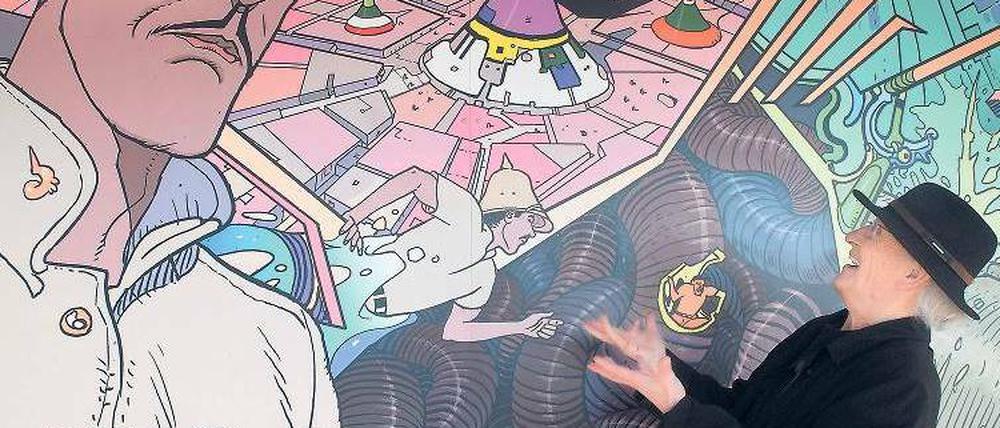 Zwei Gesichter. Jean Giraud 2008 vor einem Wandbild, das die von ihm geschaffene Figur des Major Grubert zeigt, einen Abenteurer, der Raum und Zeit bereist.