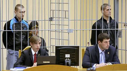 Die beiden Verurteilten Wladislav Kowaljow (rechts) und Dmitri Konowalow stehen am 15.09.2011 in einem vergitterten Käfig im Minsker Justizpalast. 