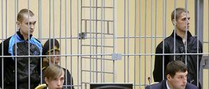 Die beiden Verurteilten Wladislav Kowaljow (rechts) und Dmitri Konowalow stehen am 15.09.2011 in einem vergitterten Käfig im Minsker Justizpalast. 