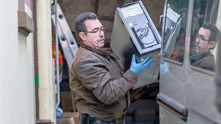 Ermittler stellen einen Computer des rechten Wohnprojektes "Braunes Haus" in Bad Neuenahr-Ahrweiler sicher.