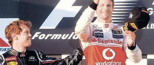 Ausnahmsweise darfst du mal. Sebastian Vettel (links) gratuliert Jenson Button zu dessen Sieg in Melbourne. Foto: dpa