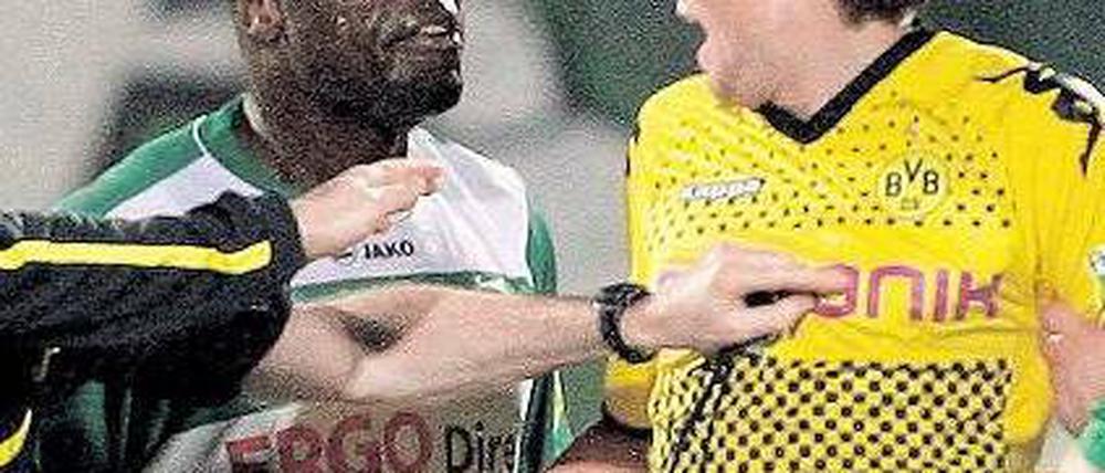 Männergespräch. Kevin Großkreutz (rechts) im feinsinnigen Dialog mit Gerald Asamoah. Foto: dpa