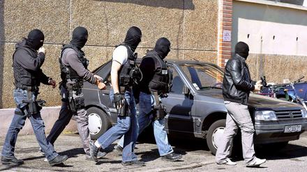Maskierte Polizisten gehen an dem Gebäude vorbei, in dem der Mehrfach-Attentäter Mohamed Merah lebte.