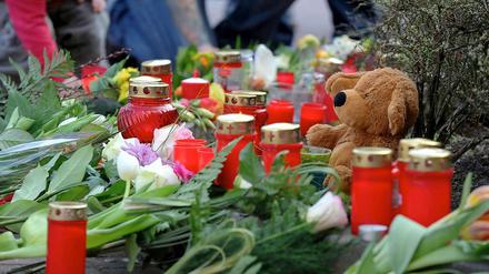 Nach dem Mord an einer Elfjährigen liegen Blumen und Kerzen an der Einfahrt zum City-Parkhaus in Emden.