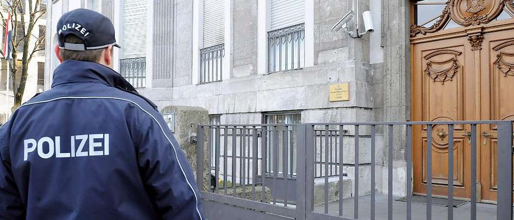 Ein Polizist steht vor eine Botschaft in Berlin. Werden solche Sicherungsmaßnahmen in Zukunft vielleicht von privaten Firmen übernommen? Der Senat will sparen. 