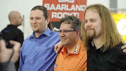 Gewinnertypen. Der Schatzmeister der Piratenpartei im Saarland, Andreas Augustin (v.l.), Michael Neyses (Piratenpartei) und der Beisitzer im Vorstand der Piratenpartei im Saarland, Michael Hilberer, posieren am Sonntagin Saarbrücken nach der Bekanntgabe der ersten Prognosen.