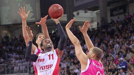 Der ehemalige Alba-Spieler Julius Jenkins (m.), nun im Dienst von der Brose Baskets Bamberg, setzt sich gegen zwei Spieler der Telekom Baskets Bonn durch.