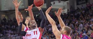 Der ehemalige Alba-Spieler Julius Jenkins (m.), nun im Dienst von der Brose Baskets Bamberg, setzt sich gegen zwei Spieler der Telekom Baskets Bonn durch.