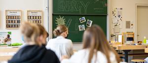 Kinder mit Mund-Nasen-Schutz sitzen im Klassenzimmer.