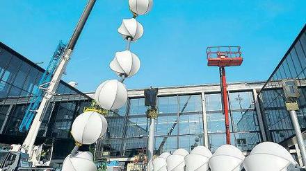Zum Kugeln. Das überdimensionale Schmuckband wird um den Zugang gelegt, der für den Riesen-Airbus A380 vorgesehen ist. Je nachdem, ob Passagiere ein- oder aussteigen, leuchten die Bälle in verschiedenen Farben. Foto: dapd/Theo Heimann