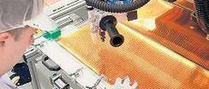 Es ist nicht alles Gold, was glänzt. Ein Techniker von Odersun verlötet in Fürstenwalde Solarmodule. Foto: p-a/dpa