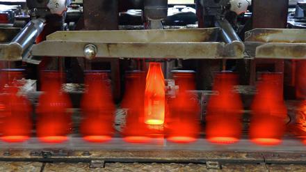 Die Neue. Diese Bierflasche hat die Glasformmaschine soeben neu hergestellt. Sie wird aus der Form aufs Band gehoben. 