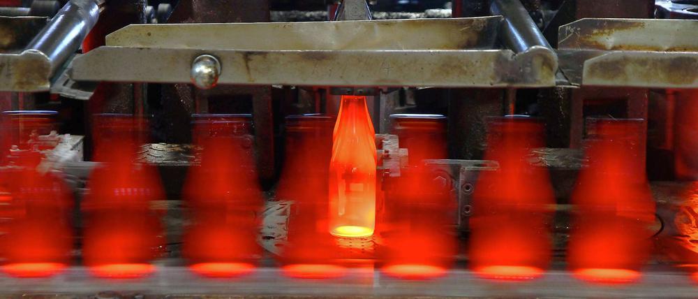 Die Neue. Diese Bierflasche hat die Glasformmaschine soeben neu hergestellt. Sie wird aus der Form aufs Band gehoben. 