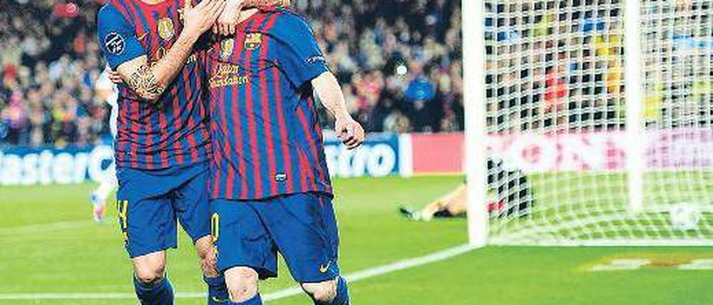 Fein gemacht. Cesc Fabregas (l.) tätschelt Lionel Messi für ein Tor – und einen Rekord.  Der Stürmer trifft so oft wie keiner vor ihm in der Champions League. Foto: dapd