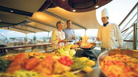 Show-Kochen an Deck. Auch am Buffet geht’s (meist) gesittet zu. Foto: dpa/tmn