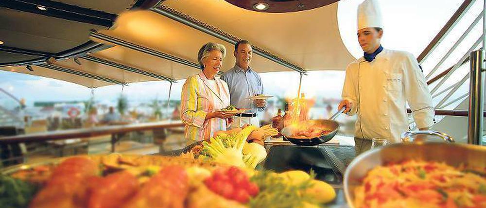 Show-Kochen an Deck. Auch am Buffet geht’s (meist) gesittet zu. Foto: dpa/tmn