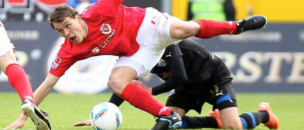 Gestrauchelt: Cottbus' Alexander Bittroff geht im Zweikampf mit Paderborns Lukas Rupp (verdeckt) zu Boden.