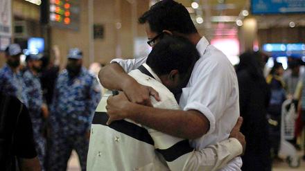 20.04.2012: Verzweifelte Angehörige von Passagieren der abgestürzten Passagiermaschine liegen sich am Flughafen von Karachi in den Armen. 