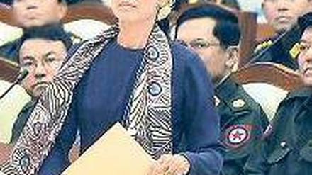 Auf dem Weg zum Eid. Aung San Suu Kyi vor Militärs im Parlament. Foto: AFP
