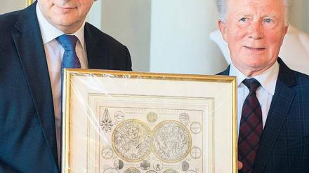 Himmlischer Geburtstag. Klaus Wowereit ehrt den früheren Kosmonauten Sigmund Jähn im Roten Rathaus mit einer Sternenkarte. Foto: Soeren Stache/dpa