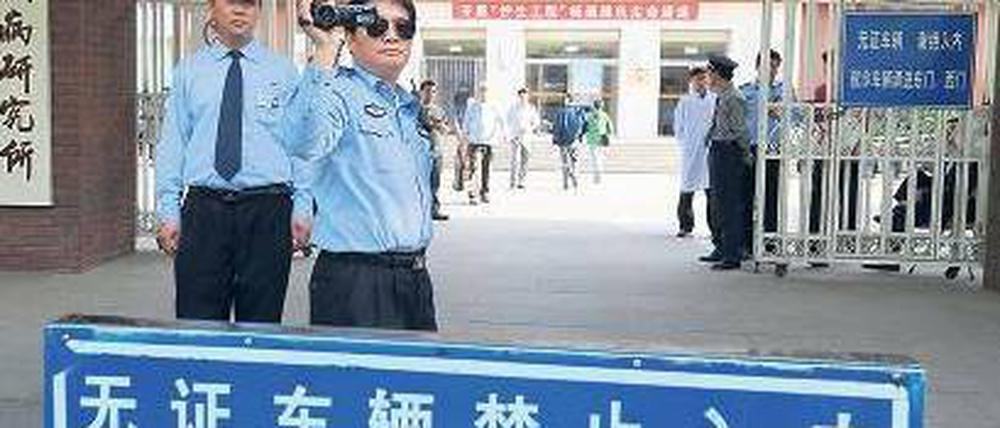 Im Visier der Polizei. Vor dem Pekinger Chaoyang-Krankenhaus, in dem sich der Menschenrechtsaktivist Chen und seine Familie befinden, filmt ein Polizeibeamter ausländische Journalisten. Foto: Mark Ralston/AFP