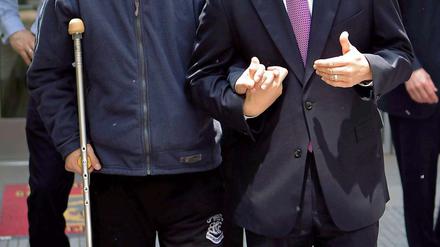 Chen Guangcheng (links) unterhält sich mit dem US-amerikanischen Botschafter in China, während sie die Botschaft für einen Krankenhausbesuch verlassen.