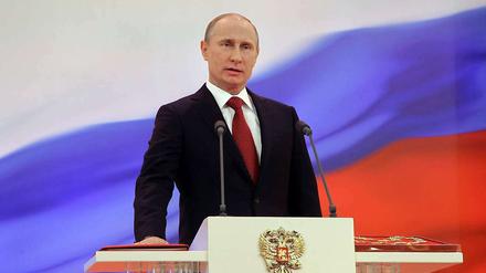 Wladimir Putin legt seine Hand auf die Verfassung.
