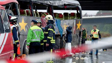 Rettungskräfte inspizieren am Sonntag den stark beschädigten Bus. Während der Rettungsarbeiten war auch ein Seelsorger vor Ort und leistete Opfern und Helfern seelischen Beistand.