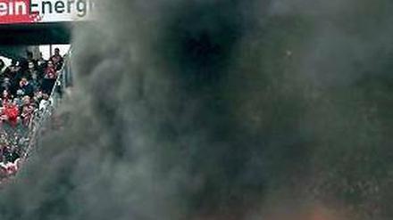 Schwarzer Rauch über grünem Rasen. In Köln regiert mal wieder das Chaos. Foto: dapd