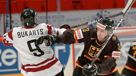 Deutschlands Justin Krueger (r.) und Lettlands Roberts Bukarts kämpfen um den Puck.