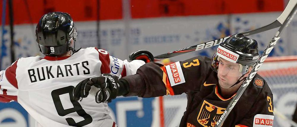 Deutschlands Justin Krueger (r.) und Lettlands Roberts Bukarts kämpfen um den Puck.