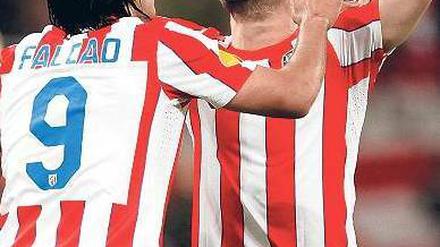 Mit der Hilfe von oben. Madrids Spielmacher Diego (M.) bedankt sich nach seinem Treffer beim lieben Gott. Doppeltorschütze Falcao (l.) stimmt mit ein. Foto: dpa