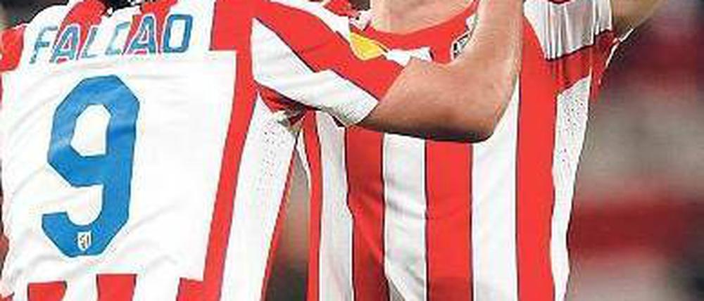 Mit der Hilfe von oben. Madrids Spielmacher Diego (M.) bedankt sich nach seinem Treffer beim lieben Gott. Doppeltorschütze Falcao (l.) stimmt mit ein. Foto: dpa