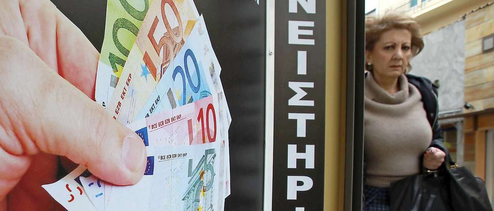 Noch bekommen Verzweifelte Euro für ihre Familienerbstücke: Eine Frau geht in Athen an einem Pfandleihgeschäft vorbei.