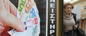 Noch bekommen Verzweifelte Euro für ihre Familienerbstücke: Eine Frau geht in Athen an einem Pfandleihgeschäft vorbei.