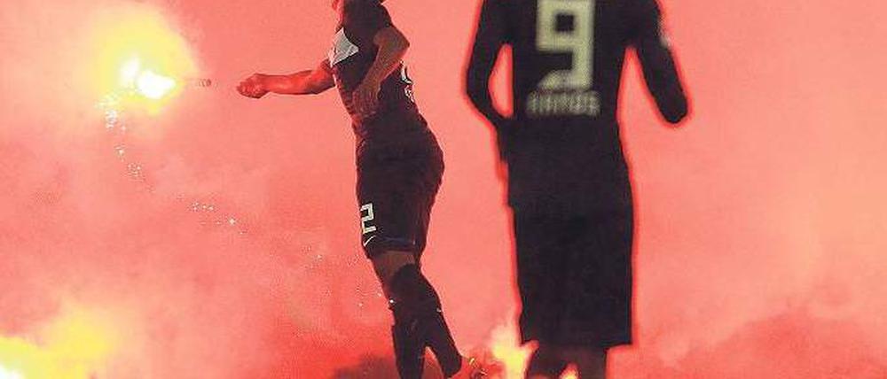 Im Fadenkreuz. In Düsseldorf warfen Hertha-Anhänger Bengalo-Fackeln, die bis zu 1600 Grad heiß brennen, auf die eigenen Spieler, wie hier Ronny (links). Foto: Reuters