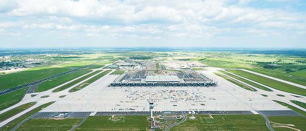Berlin baut auf. Eine kleine Orientierungshilfe aus der Luft: Das neue Flughafengebäude ist 715 Meter lang, links ist die Nordbahn (3600 Meter Länge) zu sehen, rechts die künftige Südbahn mit 4000 Meter Länge. Unten steht der 47 Meter hohe Tower. Die Straße rechts unten führt zum ILA-Gelände. Und ganz links am Bildrand ist das jetzige Schönefelder Flughafengebäude zu erkennen. Foto: dpa/Klaus-Dietmar Gabbert