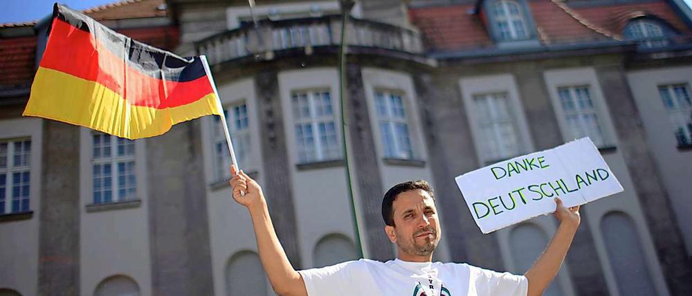 Vor der syrischen Botschaft in Berlin hält ein Demonstrant ein Schild mit der Aufschrift "Danke Deutschland" in die Höhe. Deutschland, die USA und mehrere andere Länder wiesen am Dienstag in Reaktion auf das Massaker von Hula die syrischen Botschafter aus.