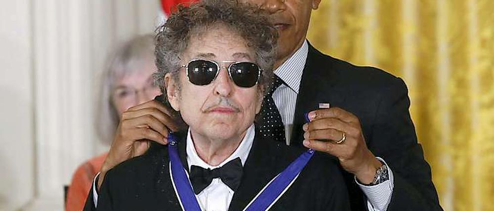 Wie eine Katze, der der Kopf gewaschen wird: Ein weniger widerwillig schien Bob Dylan sich von Barack Obama die "Medal of Freedom" umlegen zu lassen.