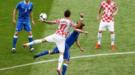 Rasentanz zwischen Mario Mandzukic und Andrea Pirlo. Thiago Motta (l.) und Ivan Rakitic schauen gebannt zu.