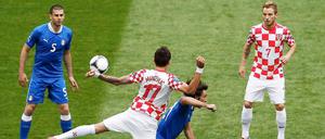 Rasentanz zwischen Mario Mandzukic und Andrea Pirlo. Thiago Motta (l.) und Ivan Rakitic schauen gebannt zu.