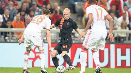 Tänzchen gefällig? Arjen Robben im niederländischen Trikot gegen seine Vereinskollegen vom FC Bayern, Holger Badstuber (l.) und Jerome Boateng.Foto: Fishing4