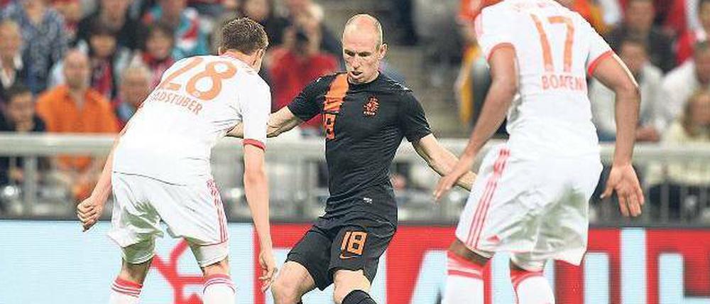 Tänzchen gefällig? Arjen Robben im niederländischen Trikot gegen seine Vereinskollegen vom FC Bayern, Holger Badstuber (l.) und Jerome Boateng.Foto: Fishing4